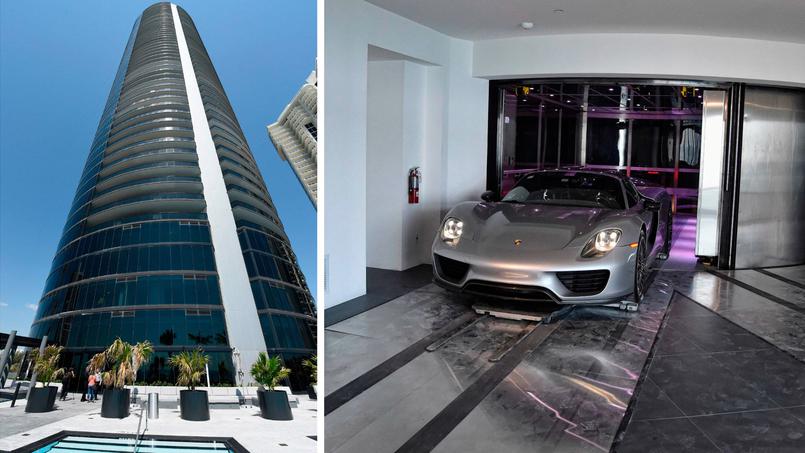 Vista exterior de la Porsche Design Tower y un Porsche plateado sobre la plataforma de su elevador para vehículos.